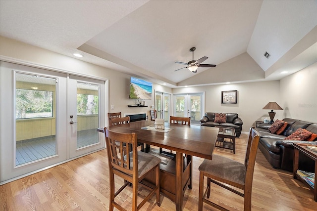 dining space featuring visible vents, ceiling fan, light wood-style floors, vaulted ceiling, and french doors