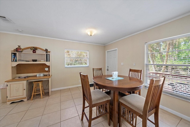 dining area featuring crown molding, visible vents, baseboards, and light tile patterned floors