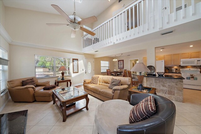 living area with light tile patterned flooring, baseboards, a ceiling fan, and visible vents