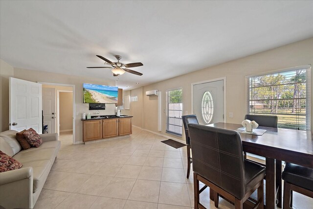 dining room featuring light tile patterned floors, an AC wall unit, baseboards, and ceiling fan
