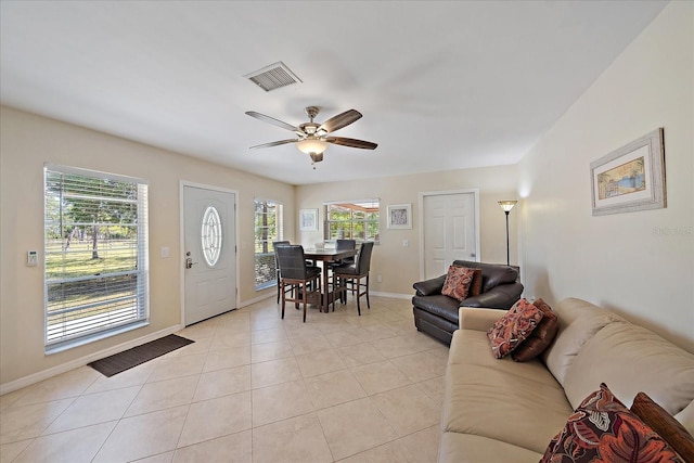 foyer entrance with light tile patterned floors, baseboards, a ceiling fan, and visible vents