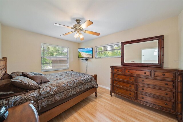 bedroom featuring baseboards, light wood-type flooring, and a ceiling fan