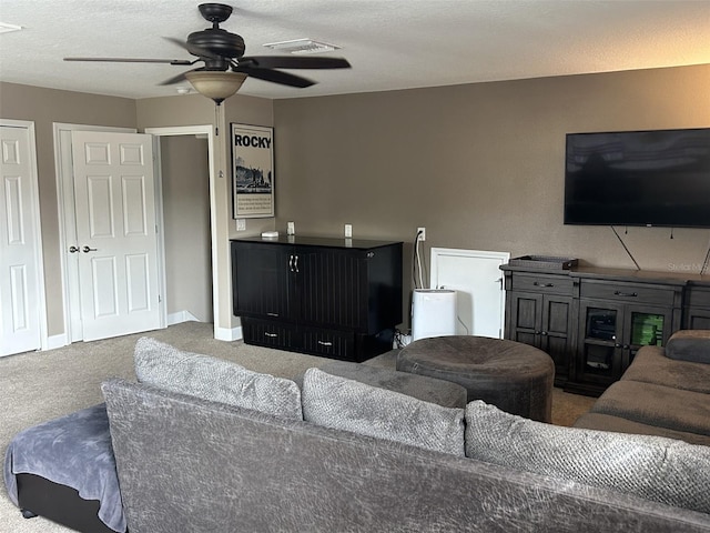 living area featuring a ceiling fan, baseboards, visible vents, and carpet