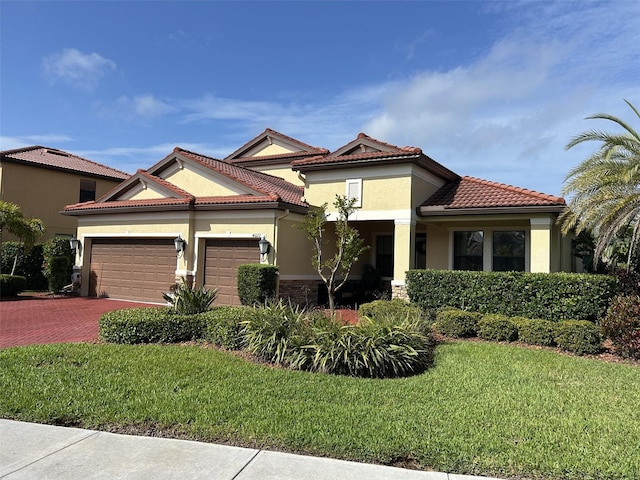 4622 Grand Lakeside Dr, Palm Harbor, FL 34684 - view of front facade with stucco siding, an attached garage, a front yard, decorative driveway, and a tiled roof