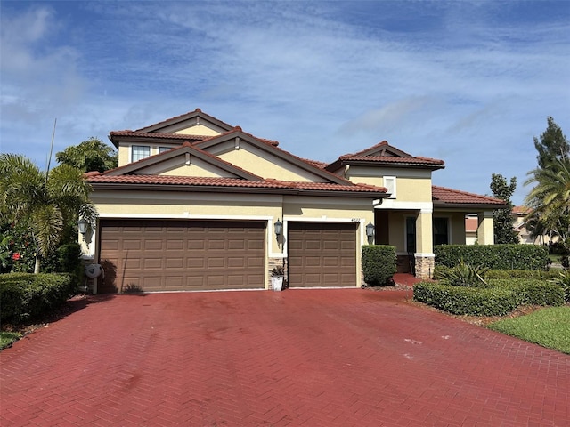 4622 Grand Lakeside Dr, Palm Harbor, FL 34684 - mediterranean / spanish-style home featuring a garage, decorative driveway, stucco siding, a tile roof, and stone siding