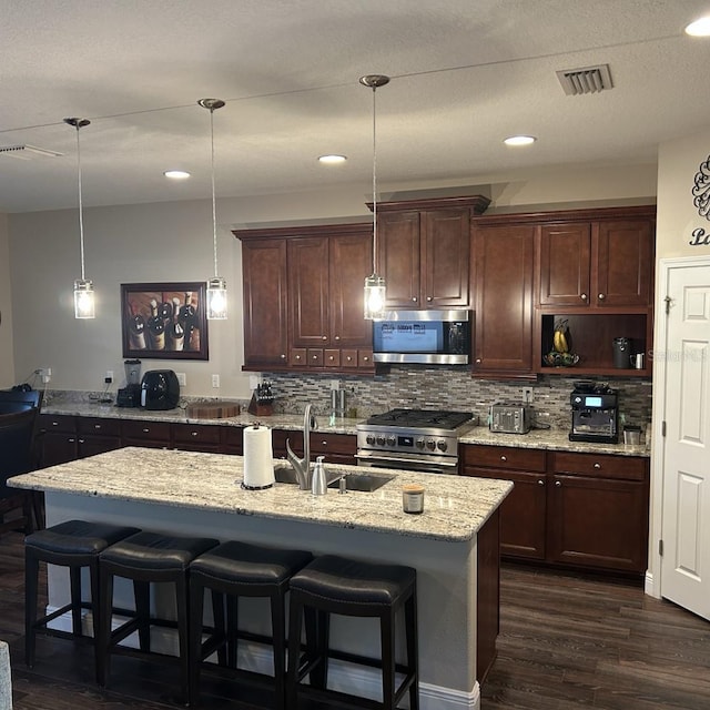 4622 Grand Lakeside Dr, Palm Harbor, FL 34684 - kitchen featuring appliances with stainless steel finishes, dark wood finished floors, tasteful backsplash, light stone counters, and recessed lighting