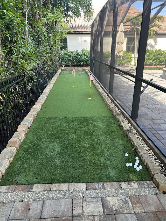 4622 Grand Lakeside Dr, Palm Harbor, FL 34684 - view of yard featuring a putting area, glass enclosure, and a patio