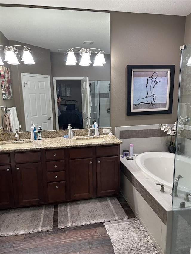 4622 Grand Lakeside Dr, Palm Harbor, FL 34684 - full bath featuring a garden tub, wood finished floors, double vanity, and a stall shower