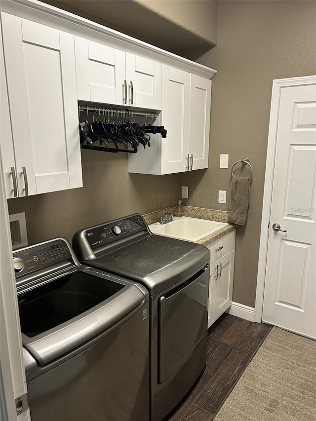 4622 Grand Lakeside Dr, Palm Harbor, FL 34684 - laundry room featuring independent washer and dryer, dark wood-style floors, cabinet space, and baseboards