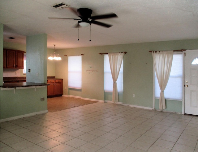 6339 Pontiac Ln, North Port, FL 34287 - unfurnished living room with a ceiling fan, a chandelier, healthy amount of natural light, and light tile patterned floors