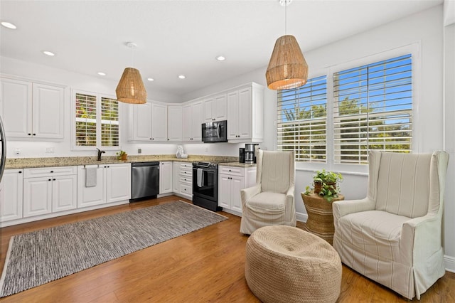 kitchen with stainless steel appliances, light wood-style floors, white cabinets, and a sink