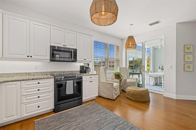 kitchen with visible vents, white cabinets, appliances with stainless steel finishes, and wood finished floors