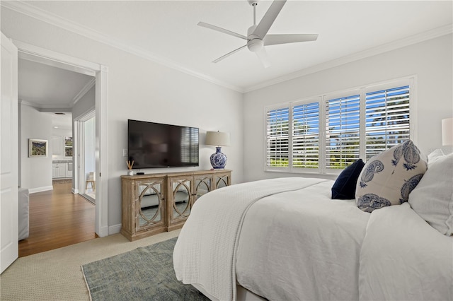 bedroom with carpet, baseboards, crown molding, and ceiling fan