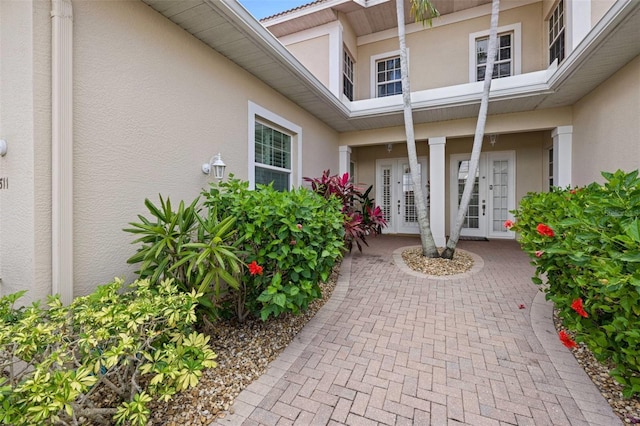 property entrance with french doors and stucco siding