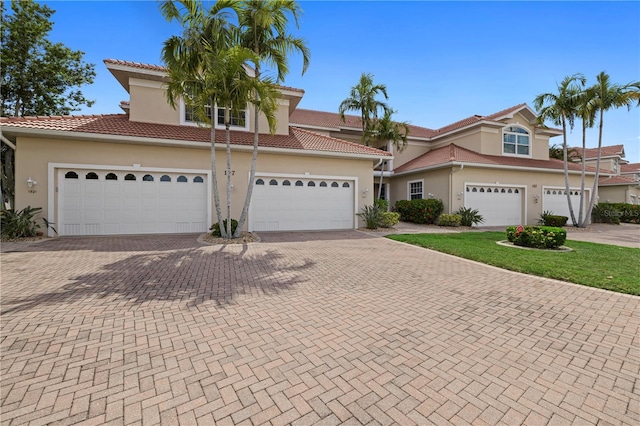 view of front of home with driveway, stucco siding, and a tile roof