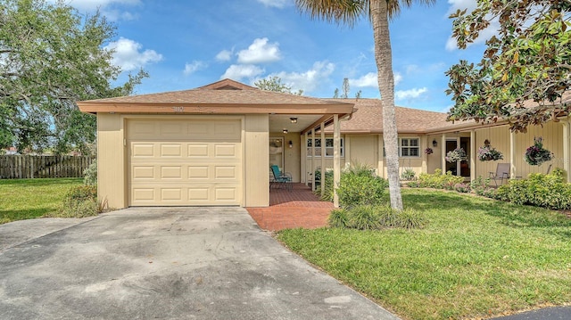 ranch-style house with a front yard, fence, driveway, and stucco siding