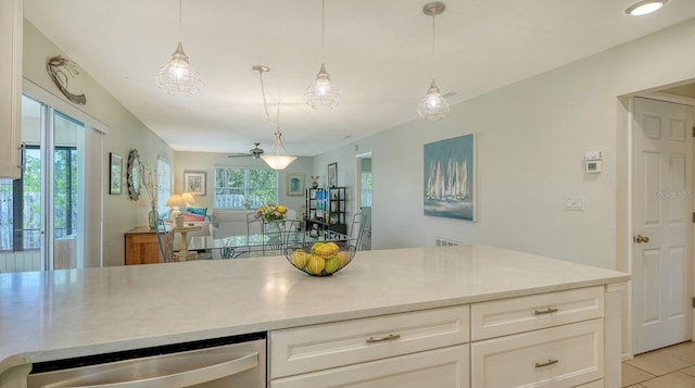 kitchen with light countertops, stainless steel dishwasher, a ceiling fan, and pendant lighting