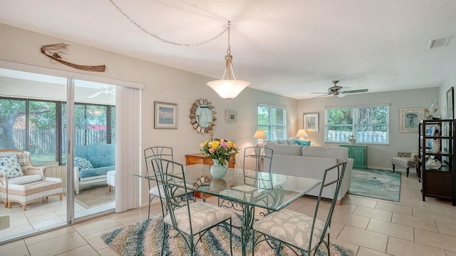 dining room with light tile patterned floors, visible vents, baseboards, and ceiling fan