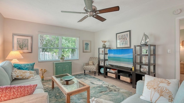living room with baseboards, a ceiling fan, and tile patterned flooring