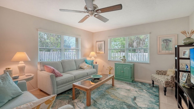living room featuring light tile patterned floors, baseboards, and ceiling fan