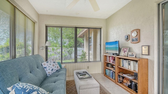 living area with tile patterned floors, a ceiling fan, and a wealth of natural light