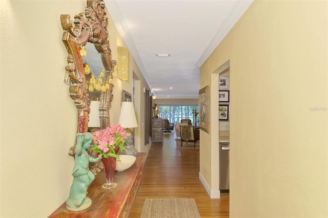 corridor featuring ornamental molding and wood finished floors