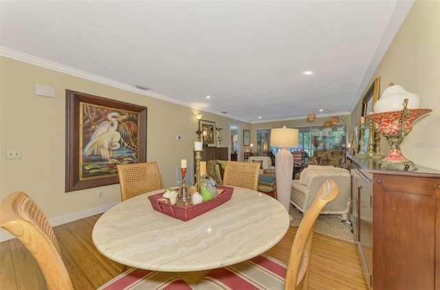dining room with crown molding, light wood-style flooring, visible vents, recessed lighting, and baseboards
