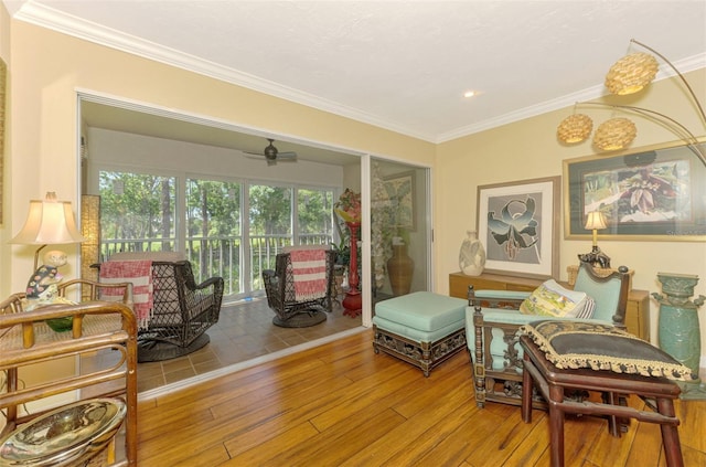 sitting room featuring ornamental molding, a ceiling fan, and wood finished floors