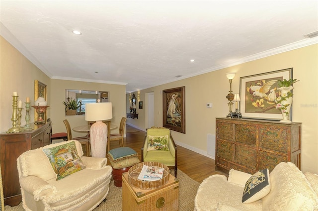living room featuring crown molding, visible vents, baseboards, and wood finished floors