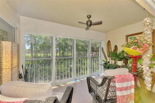 sunroom / solarium with tile patterned flooring and ceiling fan