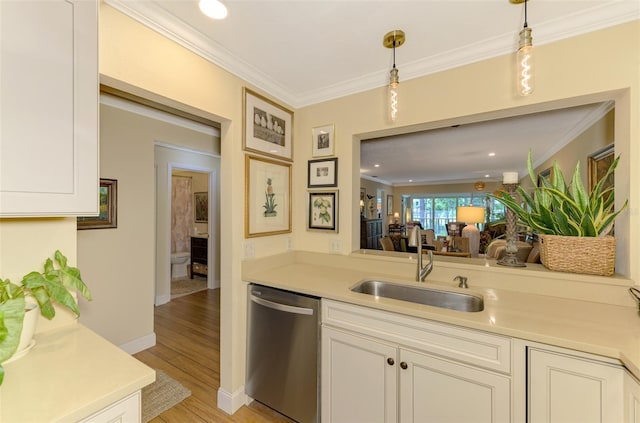 kitchen featuring light wood finished floors, dishwasher, light countertops, and a sink