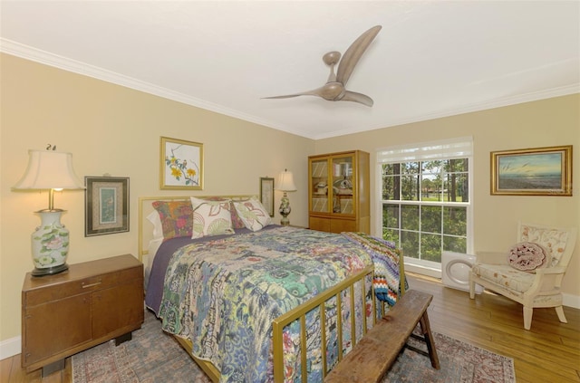 bedroom featuring crown molding, wood finished floors, and baseboards