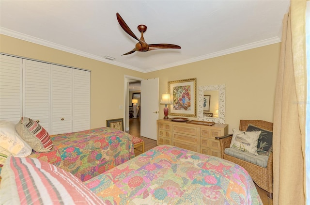 bedroom with a closet, crown molding, visible vents, ceiling fan, and wood finished floors