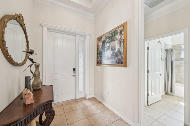 entryway with light tile patterned floors, visible vents, baseboards, and crown molding