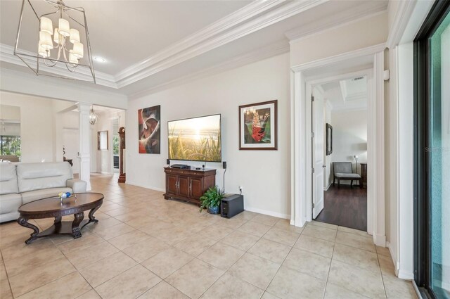interior space with baseboards, an inviting chandelier, crown molding, light tile patterned flooring, and ornate columns