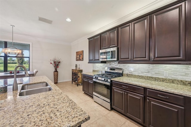 kitchen featuring tasteful backsplash, ornamental molding, dark brown cabinets, stainless steel appliances, and a sink