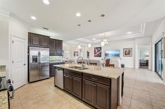 kitchen with a raised ceiling, a sink, ornamental molding, and stainless steel appliances