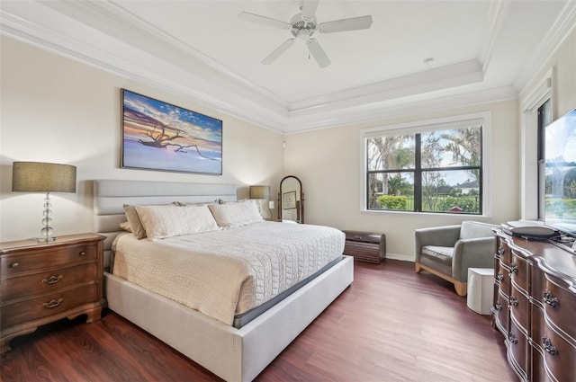 bedroom featuring baseboards, a raised ceiling, dark wood-style flooring, ceiling fan, and crown molding