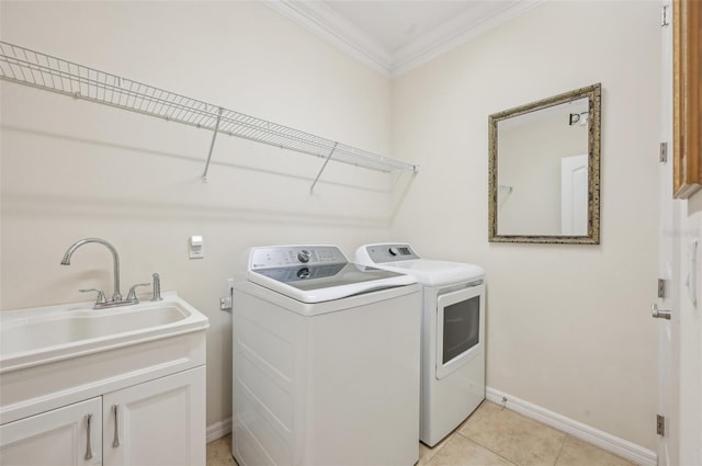 laundry area featuring crown molding, independent washer and dryer, a sink, baseboards, and cabinet space
