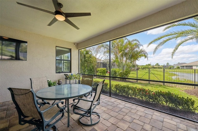 sunroom with outdoor dining space and ceiling fan