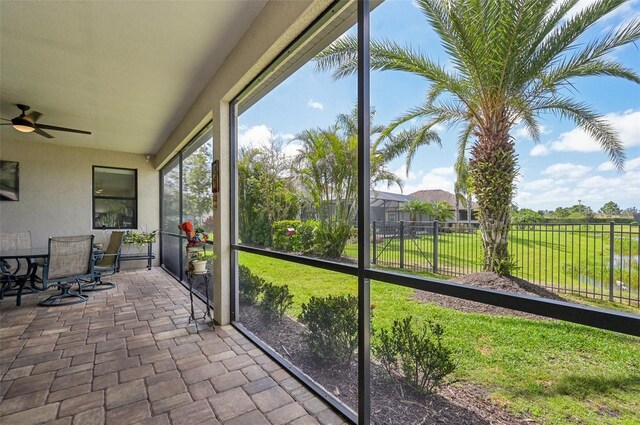 sunroom featuring outdoor dining area and a ceiling fan