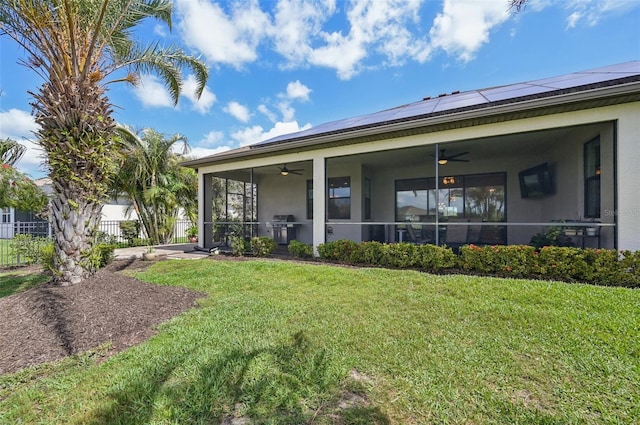 rear view of property with a sunroom, stucco siding, and a ceiling fan