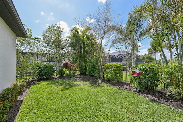 view of yard with fence and a lanai