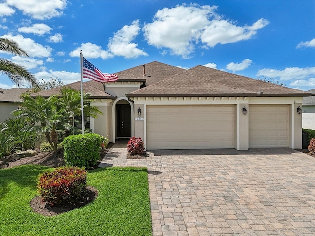 view of front of home featuring an attached garage, decorative driveway, and stucco siding