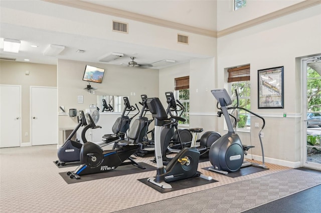 gym with visible vents, a ceiling fan, and a healthy amount of sunlight