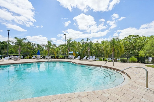 community pool featuring a patio area and fence