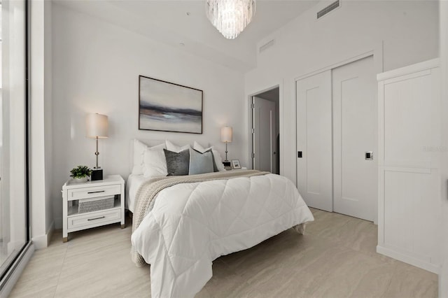 301 Quay Commons Unit 507, Sarasota, FL 34236 - bedroom with baseboard heating, a closet, and a chandelier