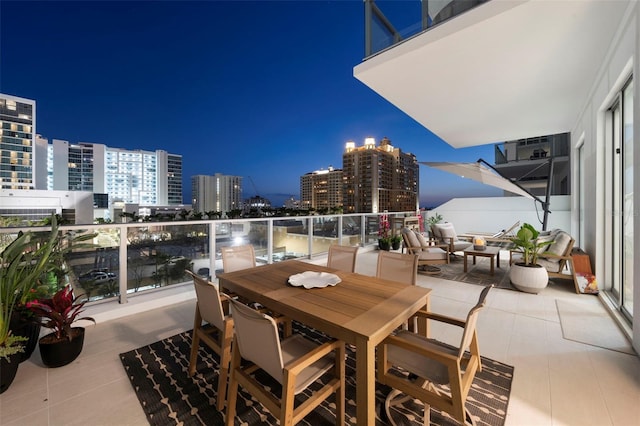 301 Quay Commons Unit 507, Sarasota, FL 34236 - balcony at night featuring a view of city lights and outdoor dining area