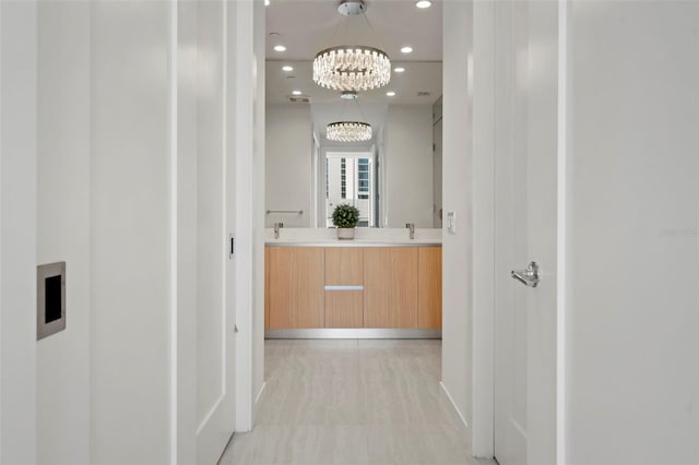 301 Quay Commons Unit 507, Sarasota, FL 34236 - hall with recessed lighting, a chandelier, baseboards, and a sink