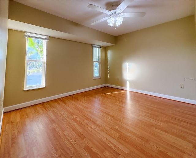 empty room with light wood-style floors, ceiling fan, and baseboards